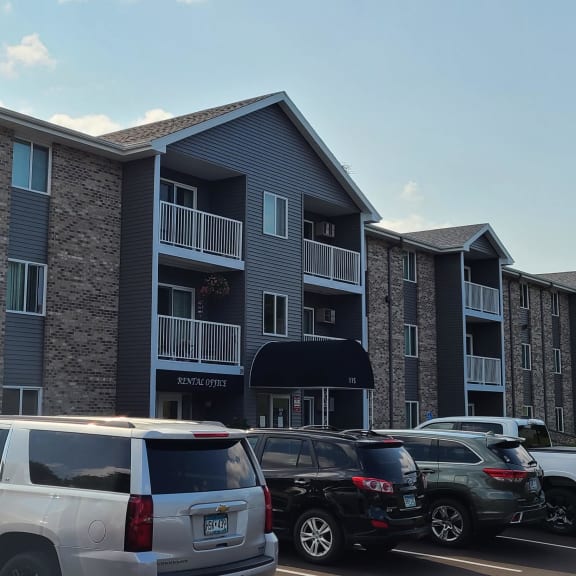 an apartment building with cars parked in front of it