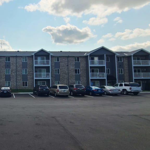 an empty parking lot in front of an apartment building
