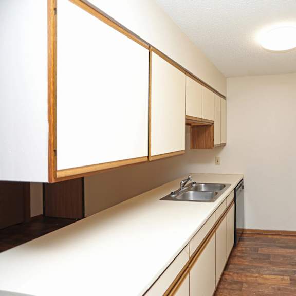 a kitchen with white appliances and wooden cabinets.