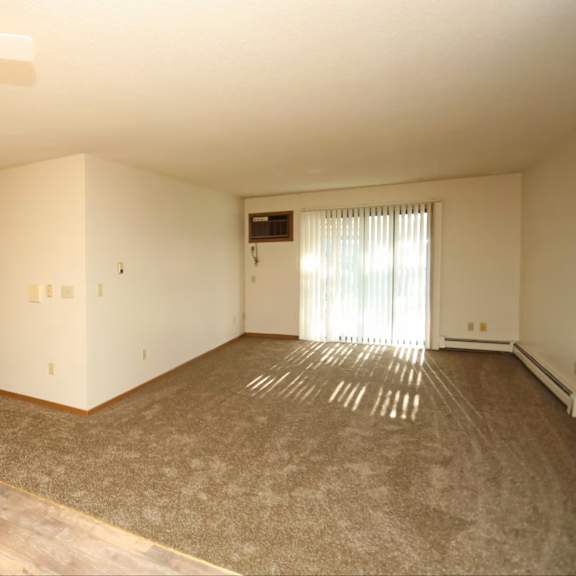 a room with a ceiling fan and a window with curtains.