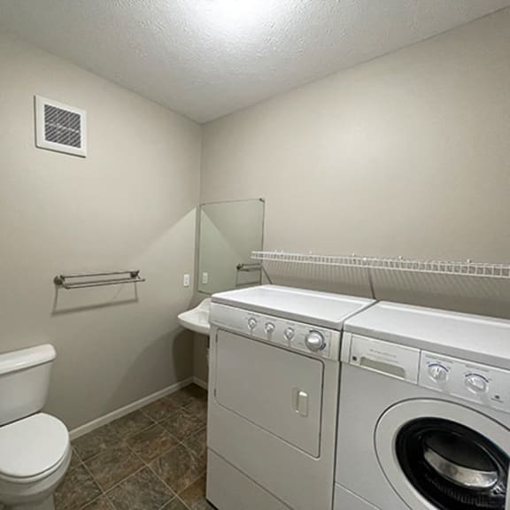 a laundry room with a toilet and a washing machine
