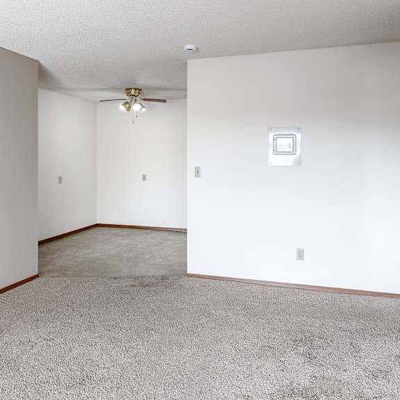 a room with a carpeted floor and a ceiling fan.