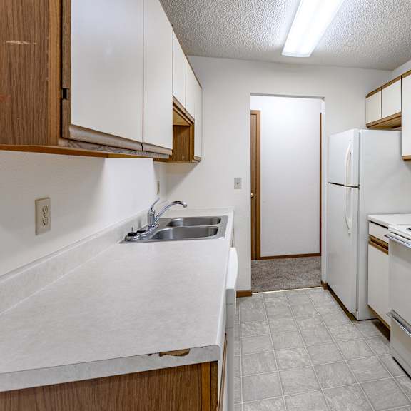 a kitchen with white appliances and wooden cabinets.