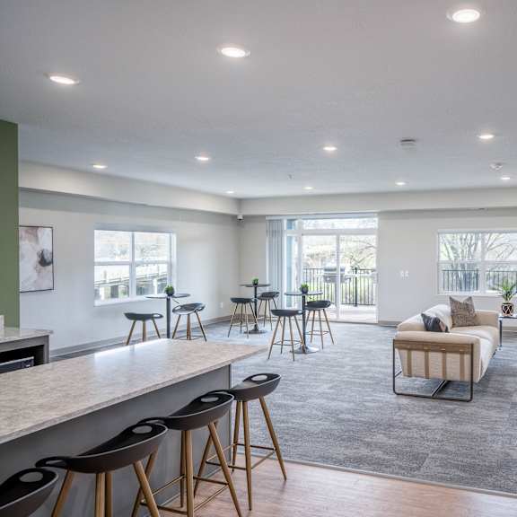 a living room with couches and chairs and a bar