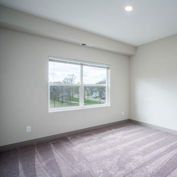 an empty room with carpet and a window