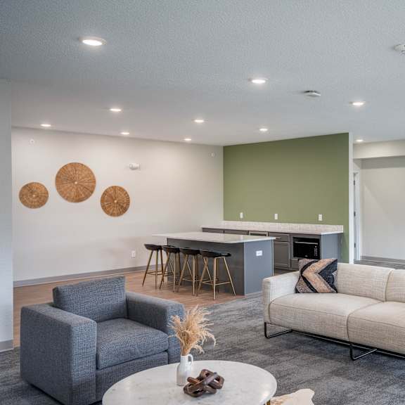 a living room with a couch and chairs and a kitchen with a table