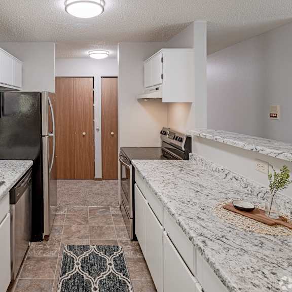 a kitchen with granite countertops and white cabinets.