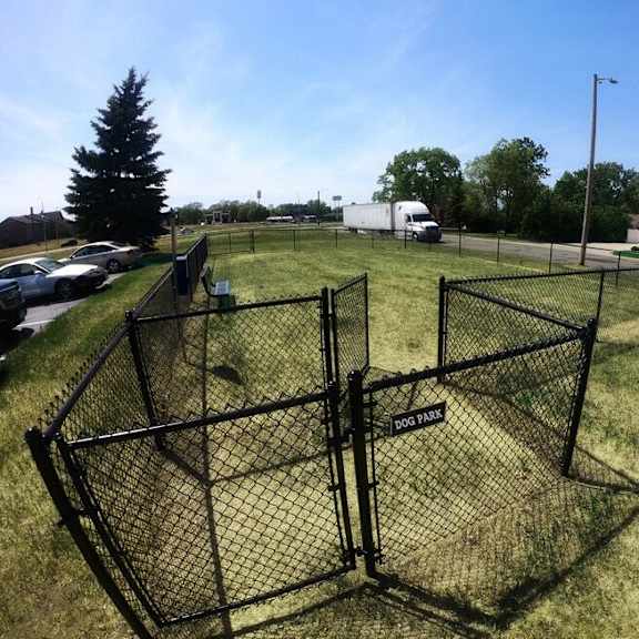 a large black fenced area in the middle of a grassy field.