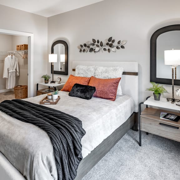 a bedroom with a bed and a mirror on the wall