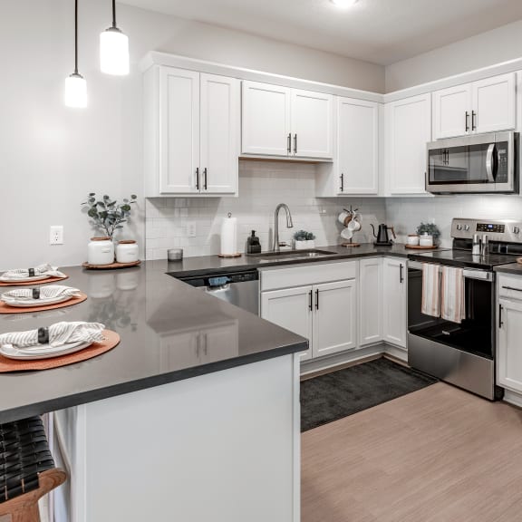 an open kitchen with stainless steel appliances and white cabinets