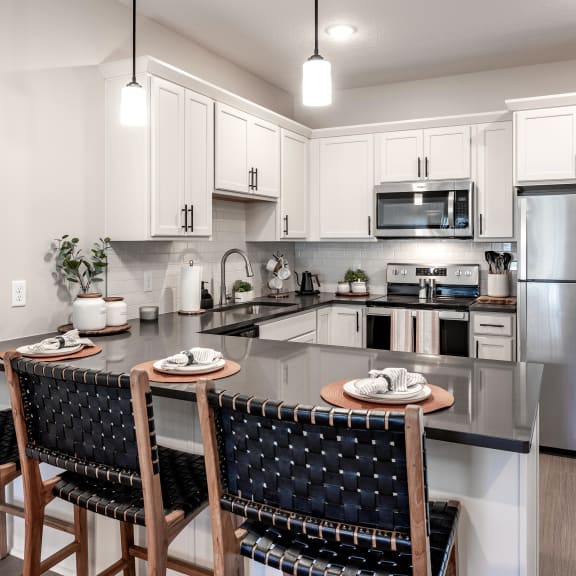 spacious kitchen with stainless steel appliances and a island with chairs