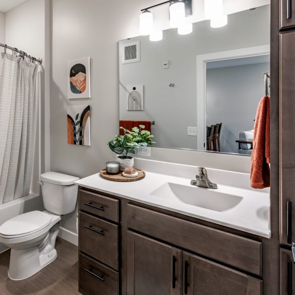 a bathroom with a toilet sink and shower and a mirror