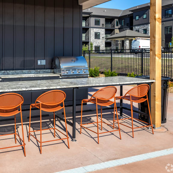 a bar with chairs in front of a grill