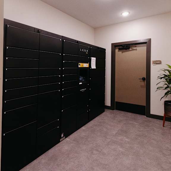 a row of black lockers in a room with an open door