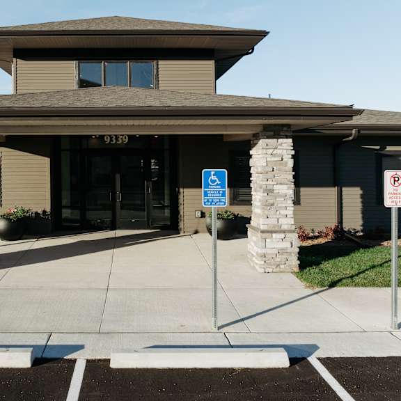 the front entrance of a building with a handicapped entrance sign