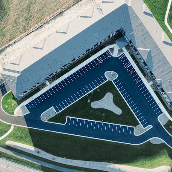 an aerial view of a large building with a football field on the roof