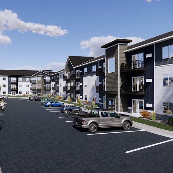 a row of modern townhouses with cars parked in front.