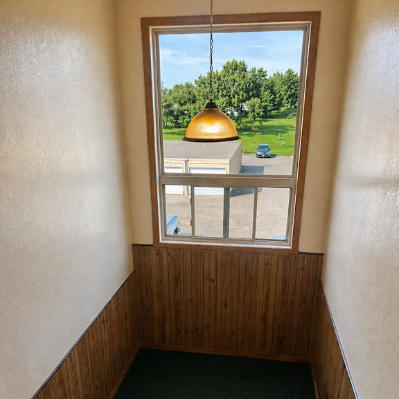 a view from inside a room looking out through a window at a green lawn and a yellow dome.