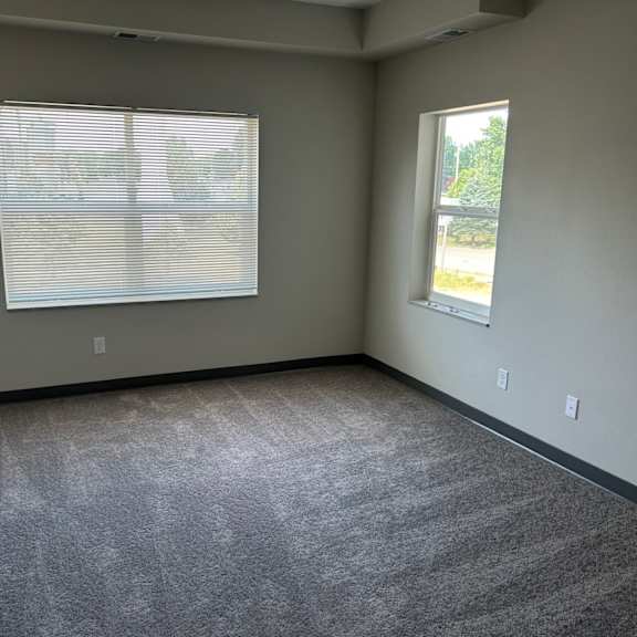 an empty room with carpet and a window