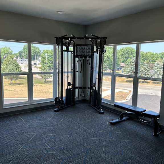 a gym with large windows in the corner of a room
