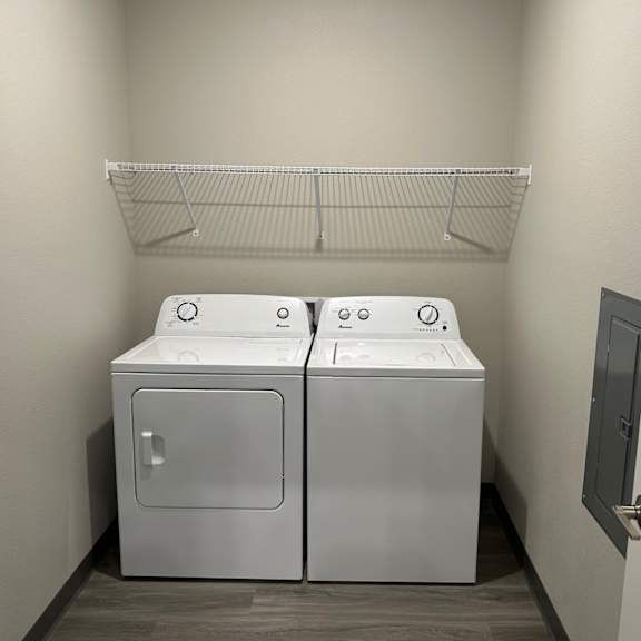 an empty laundry room with two washes and a dryer
