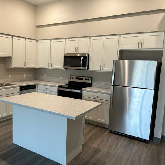 a kitchen with white cabinets and stainless steel appliances
