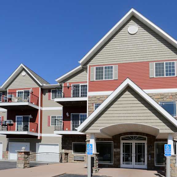 a large apartment complex with a stone entrance and a blue sign.