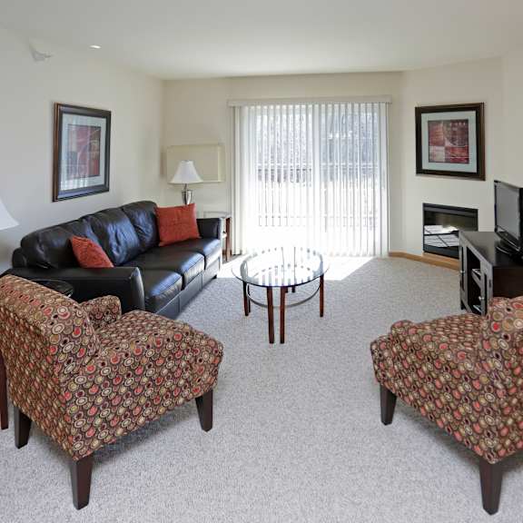 a living room with a couch, two chairs, and a television.