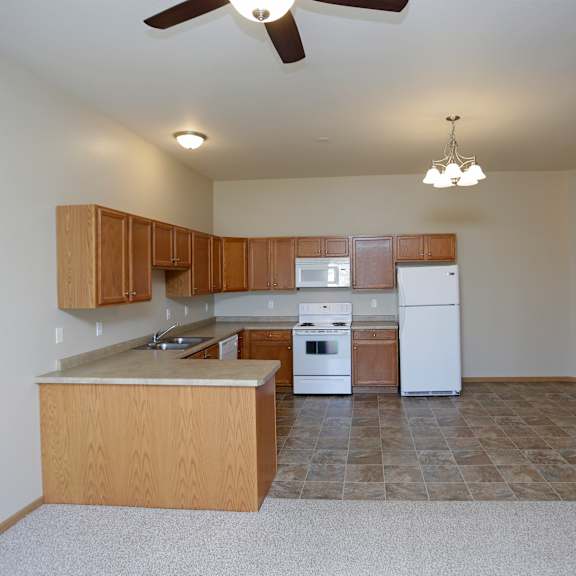 a kitchen with a white refrigerator and a fan on the ceiling.