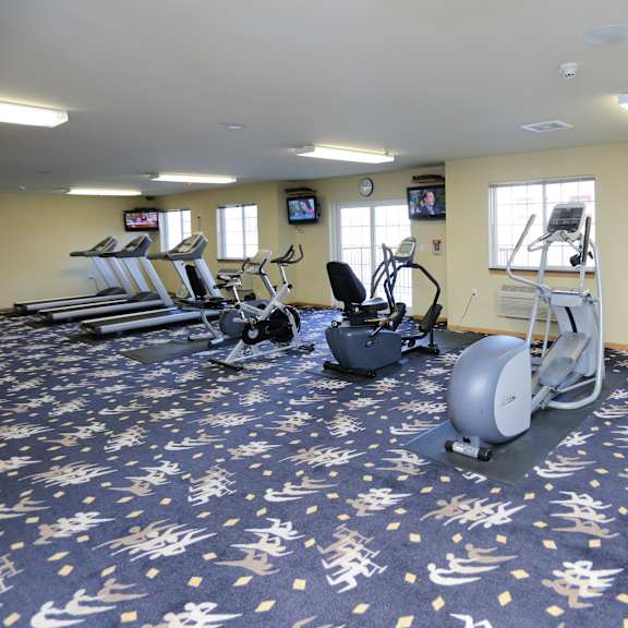 a gym with exercise equipment and a television.