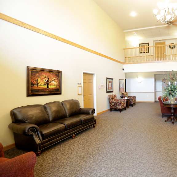 a living room with a couch, chair, and a painting on the wall.