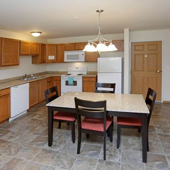 a kitchen with a table and chairs in the middle.