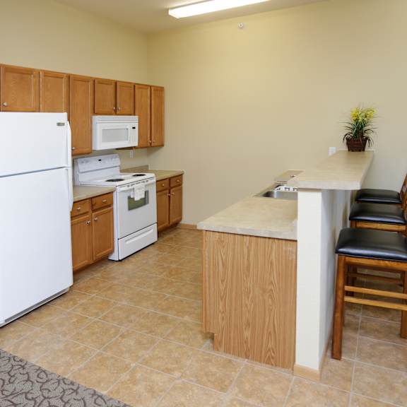 a kitchen with a white refrigerator, microwave, and oven.