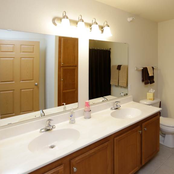 a bathroom with a white counter top and a toilet in the corner.
