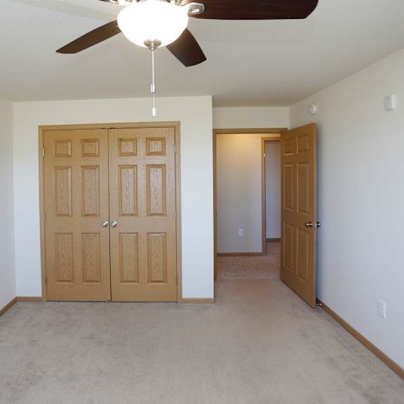 a room with a ceiling fan and two doors.