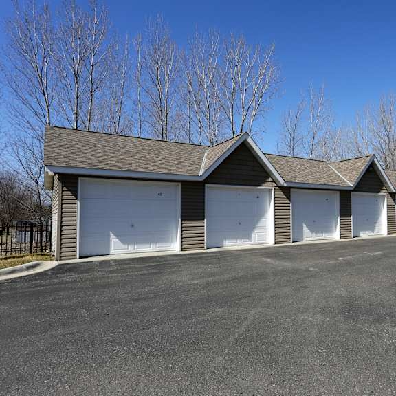 a row of garages with white doors and a clear blue sky above.