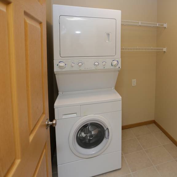 a white washing machine is in a small laundry room.