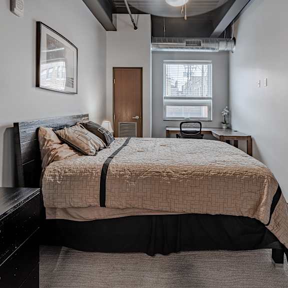 a bedroom with a bed and a dresser and a window
