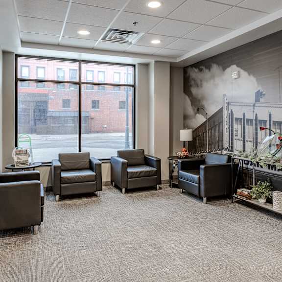 a lobby with chairs and a fireplace and a large window