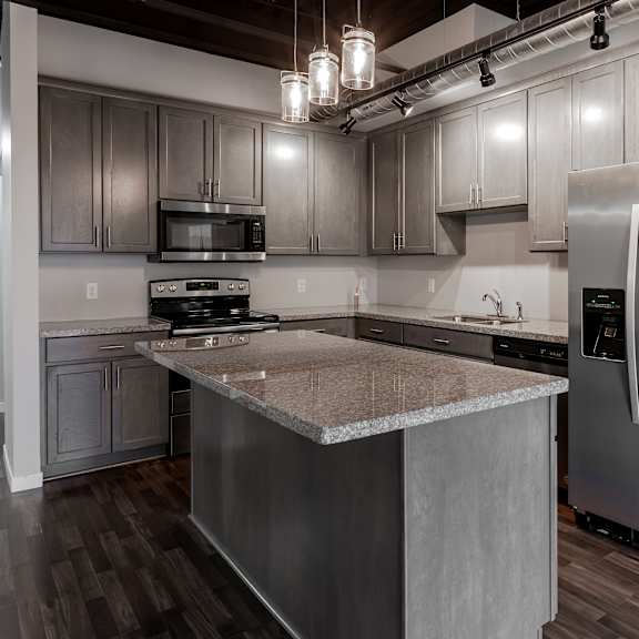 an updated kitchen with stainless steel appliances and granite counter tops