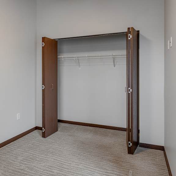 an empty room with a closet with a door open