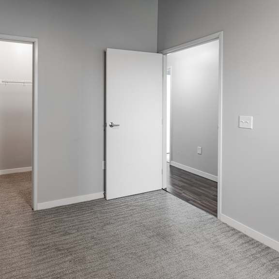 an empty room with white doors and a carpeted floor