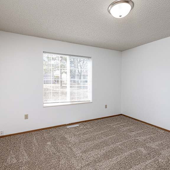 a room with a carpeted floor and a window.