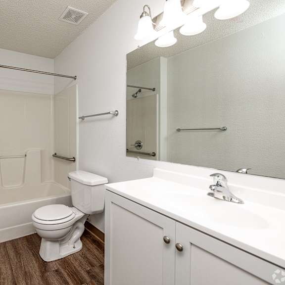 a white bathroom with a toilet, sink, and bathtub.