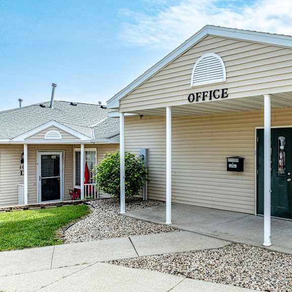 a small building with a porch and a sign that says "office".