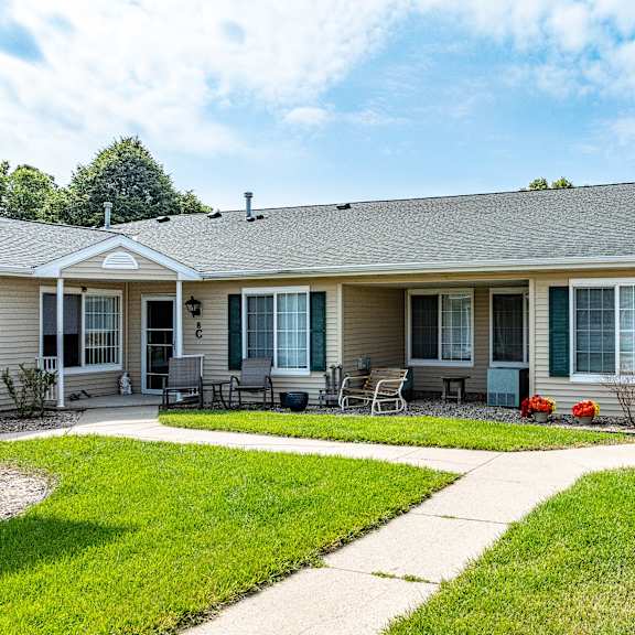 a house with a grey roof and a green lawn in front.