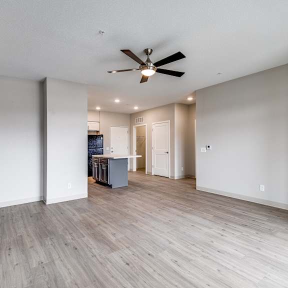 a room with a ceiling fan and wooden flooring.