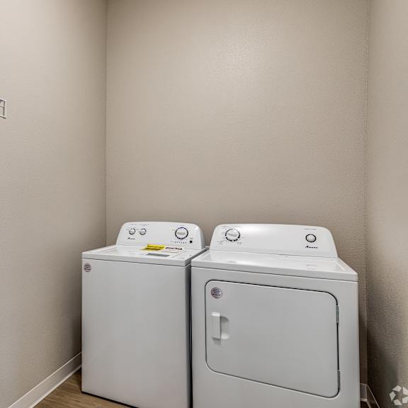 two white front loading washing machines in a laundry room.