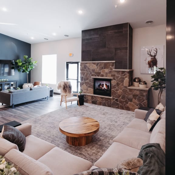 a living room with a stone fireplace and a couch and a table