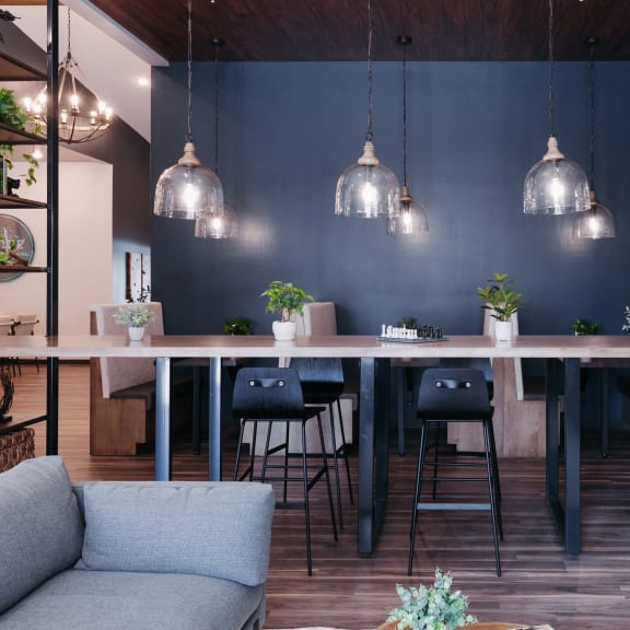 a dining room with a long wooden table and chairs and a blue wall